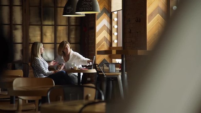 One-on-one Business Meeting in a Coffee House during Launch Break. Two Mature Business Woman Discussing improtant Project. Slow Motion. Lifestyle and Business People Concept