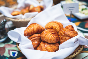Beautifully decorated catering banquet table with variety of different pastry and bakery, with croissants and cookies on corporate christmas birthday party event or wedding celebration