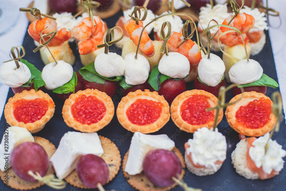 Poster beautifully decorated catering banquet table with assortment variety of different food snacks and ap