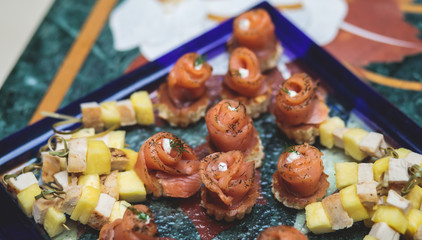 Beautifully decorated catering banquet table with assortment variety of different food snacks and appetizers on corporate christmas birthday party event or wedding celebration