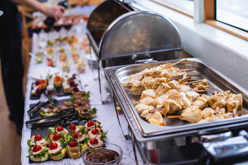 Beautifully decorated catering banquet table with assortment variety of different food snacks and appetizers on corporate christmas birthday party event or wedding celebration