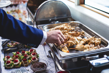 Beautifully decorated catering banquet table with assortment variety of different food snacks and appetizers on corporate christmas birthday party event or wedding celebration