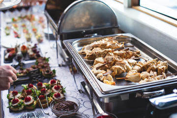 Beautifully decorated catering banquet table with assortment variety of different food snacks and appetizers on corporate christmas birthday party event or wedding celebration