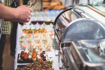 Beautifully decorated catering banquet table with assortment variety of different food snacks and appetizers on corporate christmas birthday party event or wedding celebration