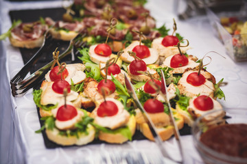 Beautifully decorated catering banquet table with assortment variety of different food snacks and appetizers on corporate christmas birthday party event or wedding celebration