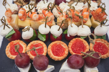 Beautifully decorated catering banquet table with assortment variety of different food snacks and appetizers on corporate christmas birthday party event or wedding celebration