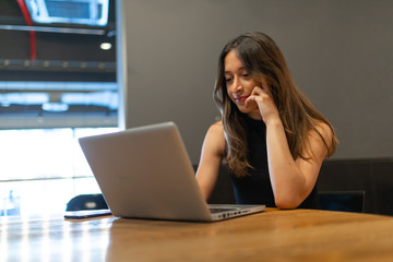 Business woman work process concept. Young woman working university project with generic design laptop. Blurred background, film effect.