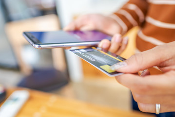 Close up young woman hands holding credit card.