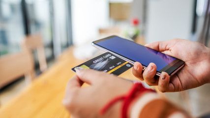 Close up young woman hands holding credit card.