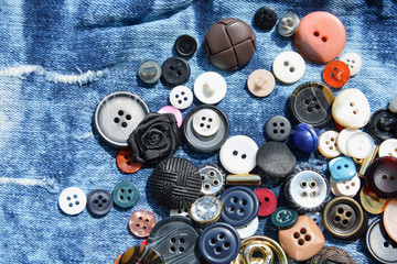 Texture of worn denim fabric with multi-colored sewn buttons for backgrounds.Jeans