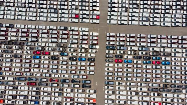 Aerial Top view of new cars lined up at Industrial factory Port, Logistics import - export and transportation concept