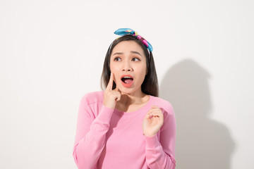 Young beautiful Asian woman scared of sunshine isolated over white background. Concept for summer skin care and skin protection from uv sunshine