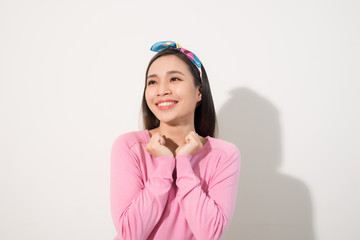 Surprised woman with hands up amazed or shocked by unexpected news holding close palms up and showing happy expression. Young adult woman on white background