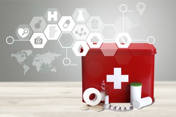 First aid kit  with medical supplies on light background - obrazy, fototapety, plakaty