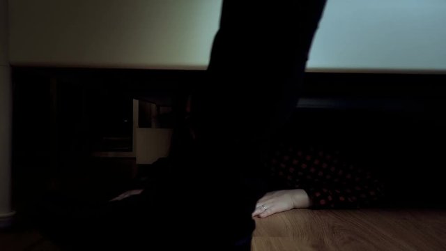 The girl hiding under the bed from a pursuer, a robber, a rapist, a criminal of an evil husband or father. Domestic violence concept.