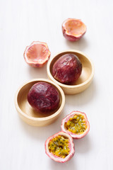 Fresh passion fruit in a wooden bowl on white table, healthy fruit