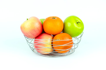Apples and oranges in a decoratively wire basket put on isolated white background with clipping path.
