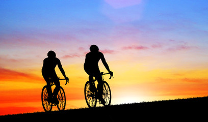 Obraz premium Silhouette group friend and bike relaxing on blurry sunset background.