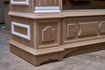 Mdf cabinet carcass with moldings and wooden carved capital. Wooden furniture manufacturing process