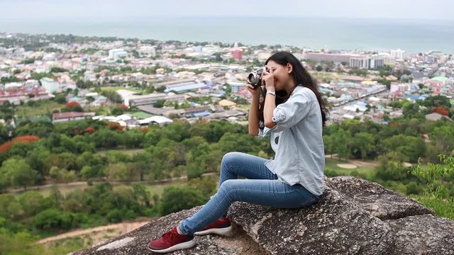 Young Asian woman travel on the hill and take photo