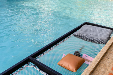 Mesh seat with pillows jut out on swimming pool