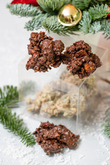 Fototapeta na wymiar Rocks with chocolate and nuts. Christmas theme. Healthy sweet dessert snack. Granola bar with nuts, fruit, chocolate and berries. Garland lamps bokeh on background. Copy space