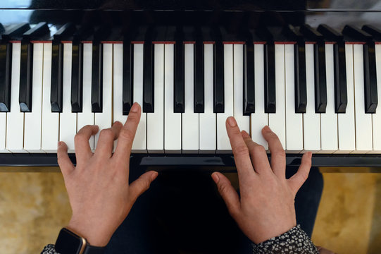 Young woman is practicing with playing the piano keyboard