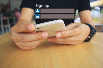 Young man using smart phone and sign up or log in username password on the wooden table in restaurant, GDPR.cyber security and privacy concept