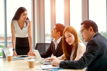 Making great decisions. Young woman gesturing and discussing something with smile while her coworkers listening to her sitting at the office table