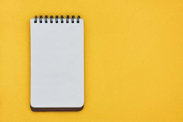 top view of empty open lined notebook on yellow blackground with copy space, flat lay