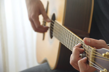 Fototapeta premium Midsection of the young man playing acoustic guitar