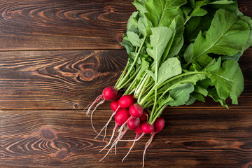 Red radish on dark wooden background.