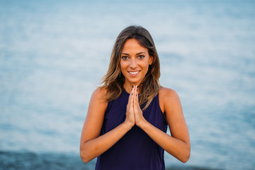 Naklejka premium Young healthy Yoga woman practicing yoga pose on the beach at sunrise, benefits of natural environments for physical, spiritual, healthy, relaxing concept.
