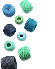 Clews of colorful knitting threads on white background, top view