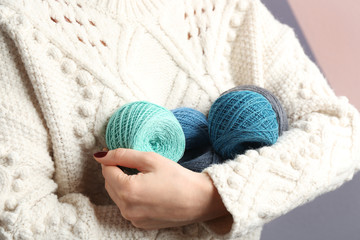 Fototapeta na wymiar Woman holding clews of knitting threads, closeup