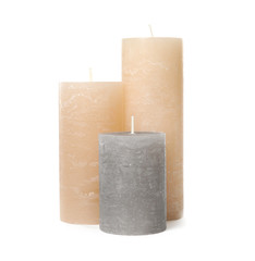 Three color wax candles on white background