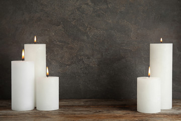 Alight wax candles on table. Space for text