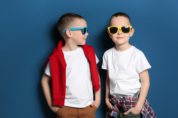 Obraz premium Portrait of cute twin brothers with sunglasses on color background
