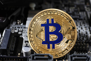 Golden bitcoin on computer circuit board, closeup. Digital currency