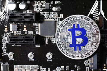Silver bitcoin on computer circuit board, top view. Space for text