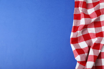 Checkered picnic blanket on color background, top view. Space for text