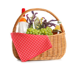 Picnic basket with flowers, wine and food isolated on white