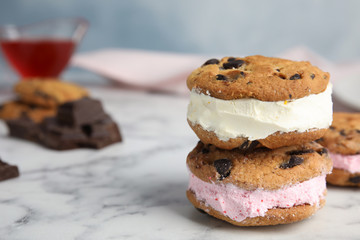 Sweet delicious ice cream cookie sandwiches on table, space for text