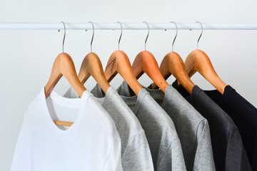 close up collection of black, gray and white color (monochrome) hanging on wooden clothes hanger in...