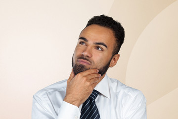 Handsome young African American man looking up with thoughtful and skeptical expression