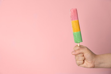 Woman holding delicious ice cream against color background, space for text