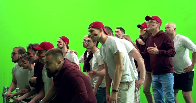 GREEN SCREEN CHROMA KEY 3/4 view group of people fans wearing red clothes celebrating during a sport event. 4K UHD ProRes 422 HQ