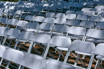 Naklejka premium White plastic chairs set up an outdoor in row before ceremony, event or party