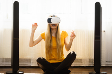 Girl wearing virtual reality goggles at home