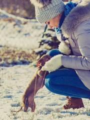 Woman playing with dog during winter